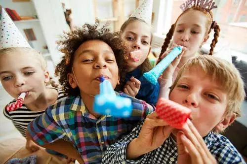 Enfants qui fêtent un anniversaire avec des sifflets en Suisse romande