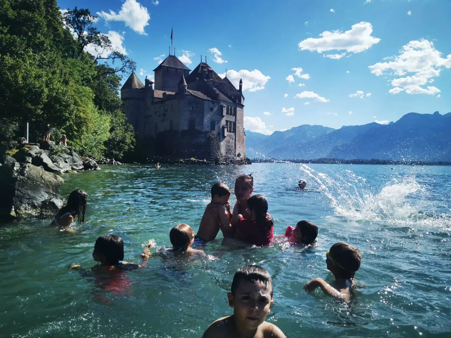 Enfants qui nagent au bord du Château de Chillon pendant un camp de vacances Kids Trip Swiss