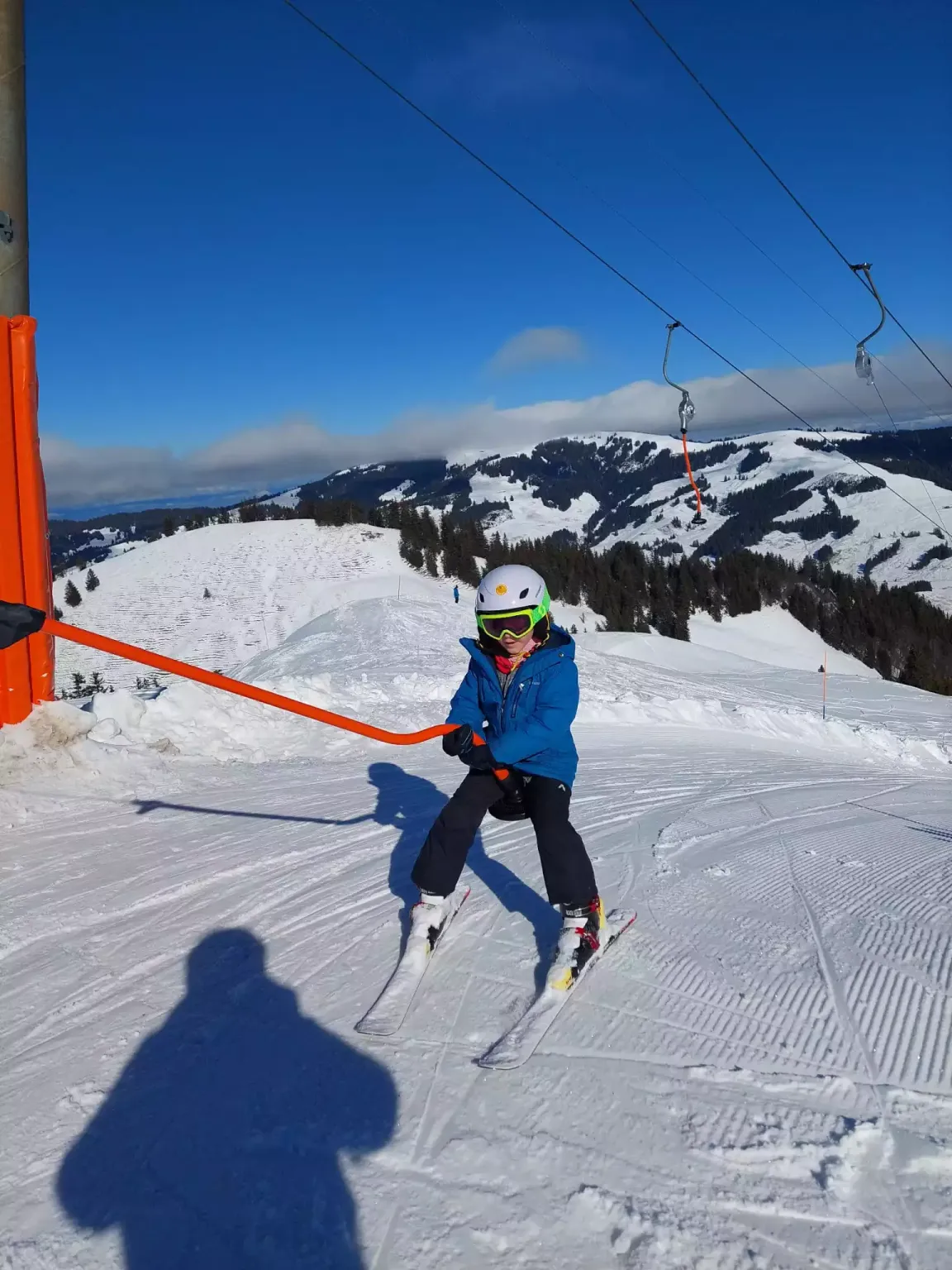 Enfant au téléski pendant un camp de ski en Suisse Romande